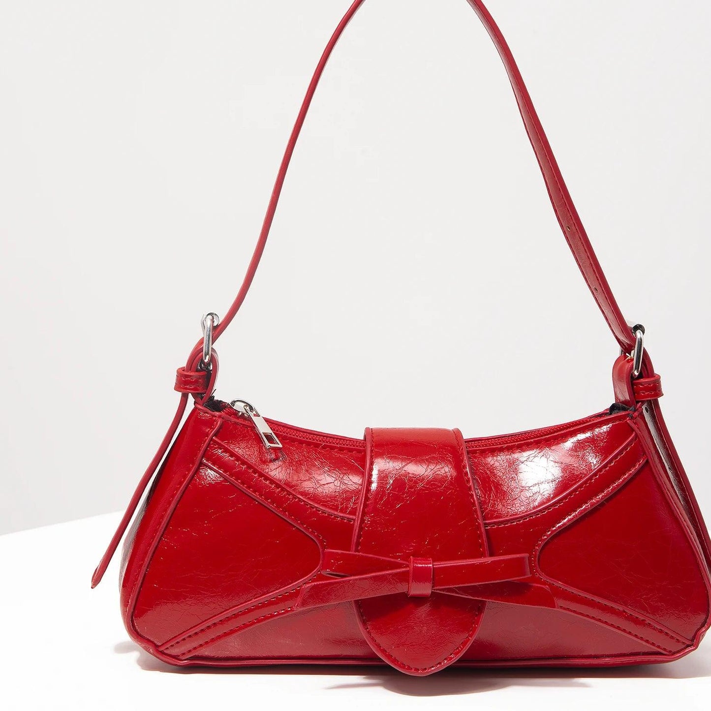 Bolso mariposa cuero vegano rojo con diseño elegante y correa ajustable para ocasiones especiales
