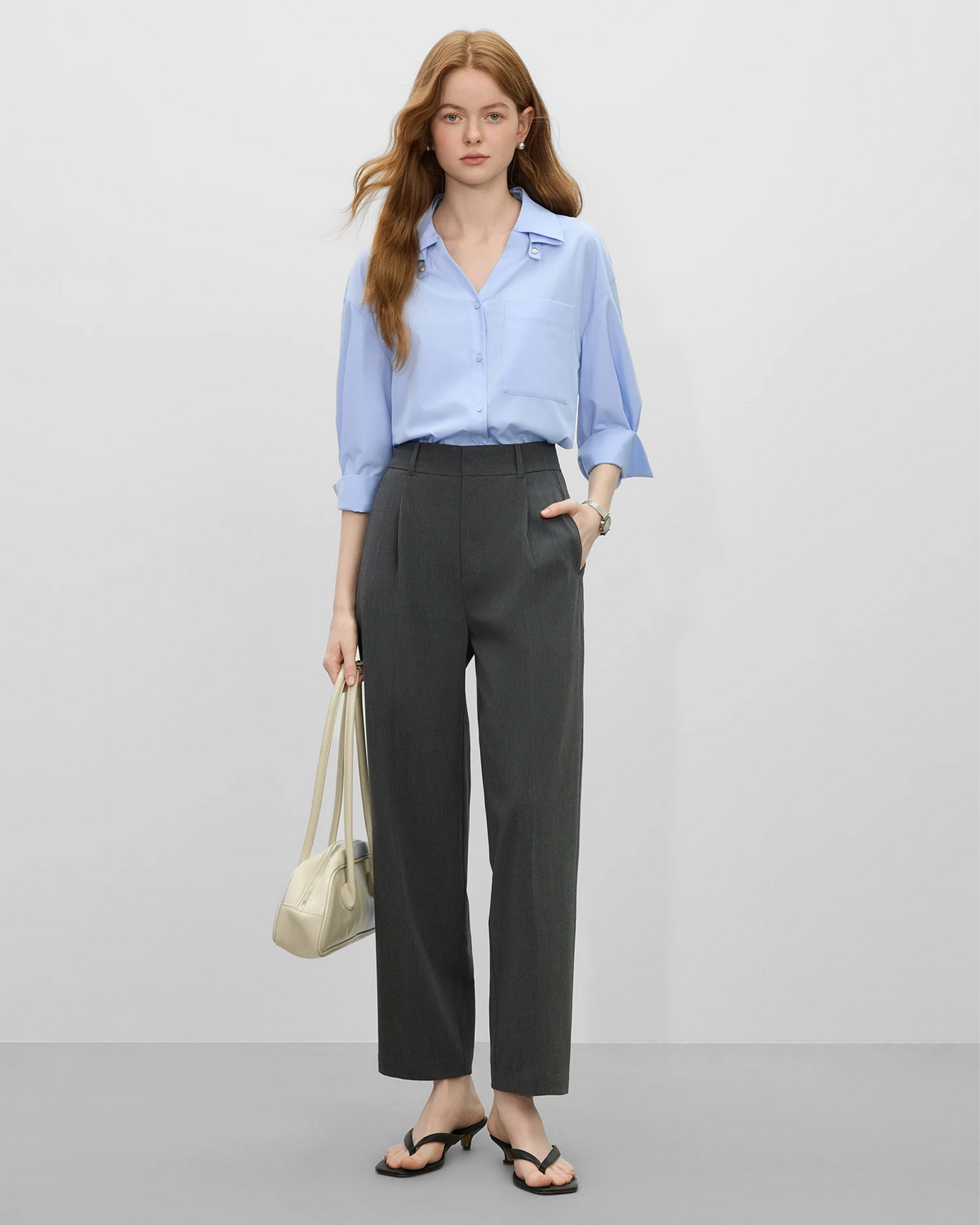 Mujer vistiendo pantalones traje grises mujer combinados con camisa azul y accesorios modernos