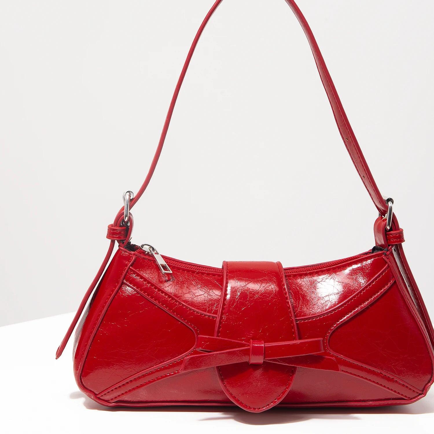 Bolso mariposa cuero vegano rojo con diseño elegante y correa ajustable para ocasiones especiales