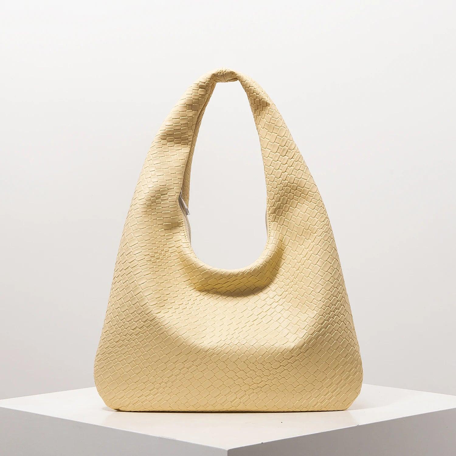 Bolso media luna trenzado en color amarillo claro, ideal para outfits casuales y elegantes