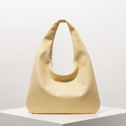 Bolso media luna trenzado en color amarillo claro, ideal para outfits casuales y elegantes