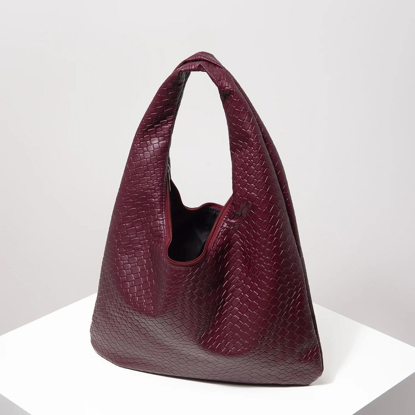 Bolso media luna trenzado de Grevano en color burdeos con diseño elegante y moderno