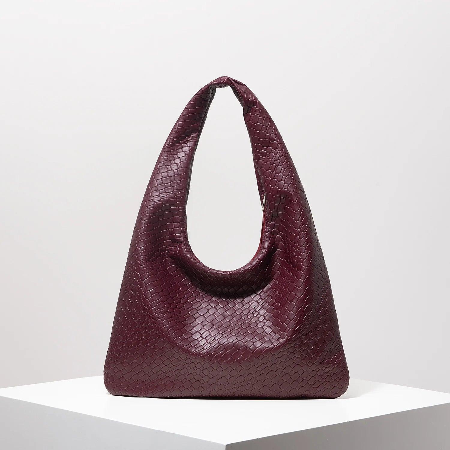 Bolso media luna trenzado en color burdeos con diseño elegante y moderno para uso diario