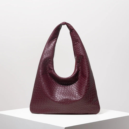 Bolso media luna trenzado en color burdeos con diseño elegante y moderno para uso diario