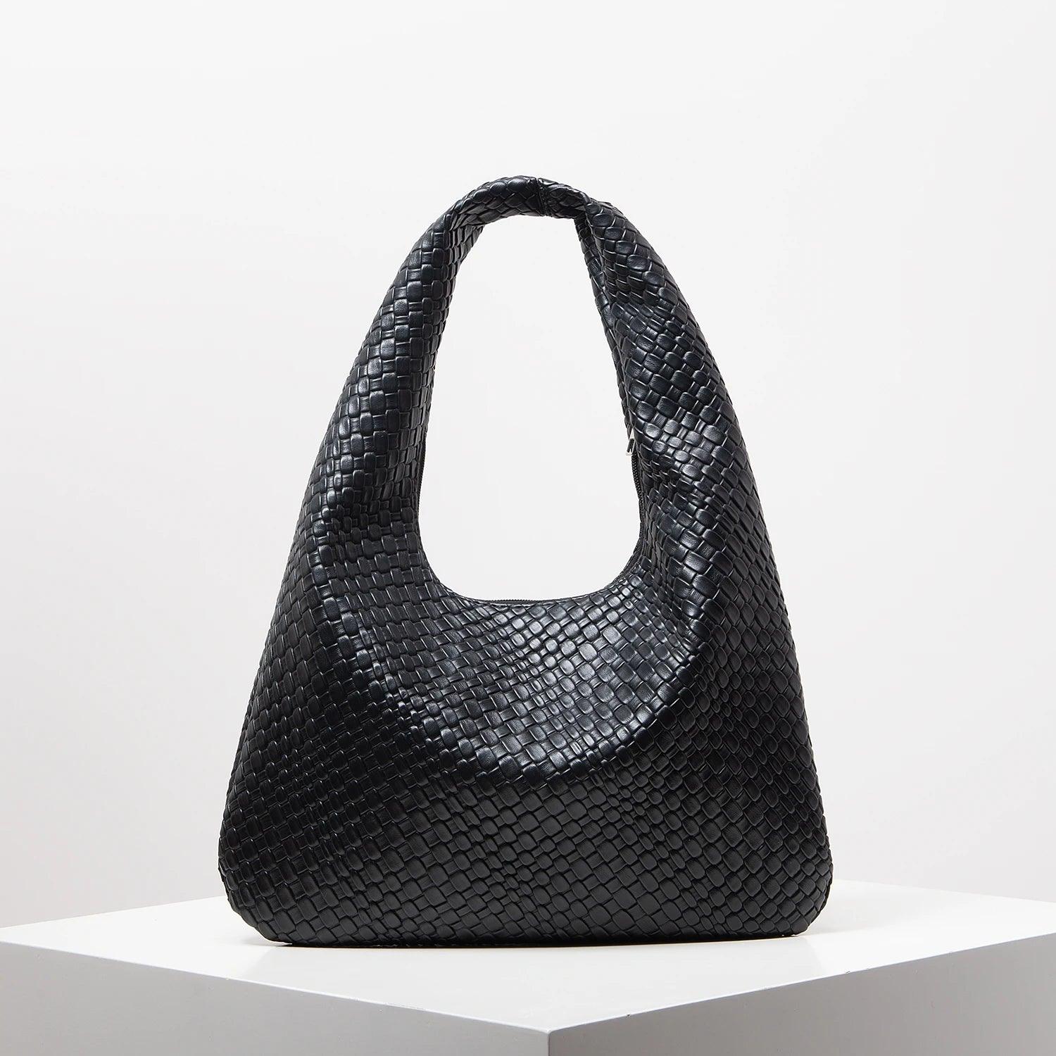 Bolso media luna trenzado en negro de Grevano con diseño moderno y elegante