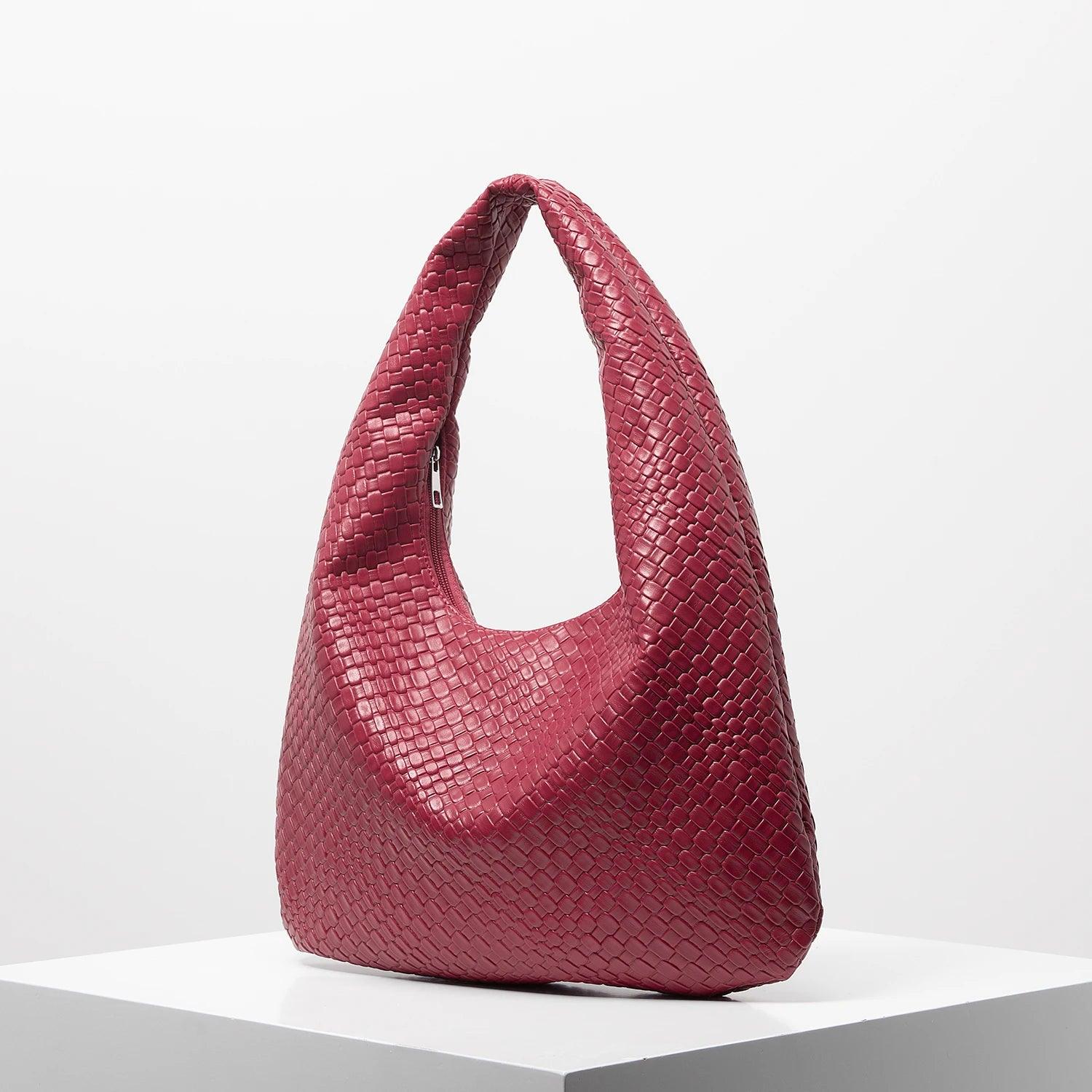 Bolso media luna trenzado en color rojo con diseño texturizado y forma moderna