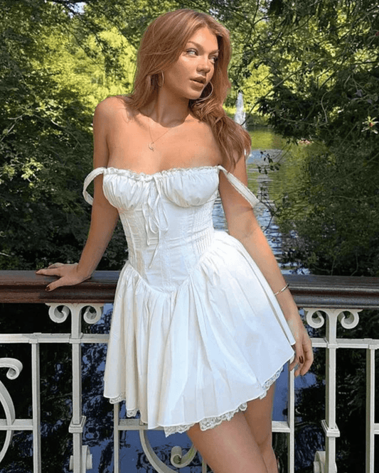 Modelo luciendo un vestido corsé blanco elegante en un entorno natural con fondo de jardín